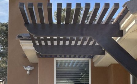 An awning attached to a home with the sun shining on it.